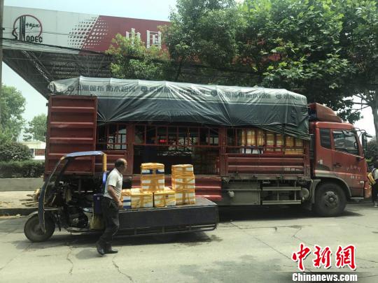 6月21日,洞庭渔都水产市场前,物流工作人员正在装运分箱的小龙虾,即刻运往贵州。 江钻 摄